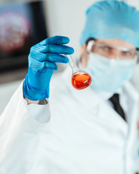 Fecha. o cientista olhando cuidadosamente para o tubo de ensaio . — Fotografia de Stock