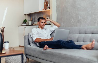 Genç girişimci akıllı telefonuyla konuşuyor. Ev hayatı..