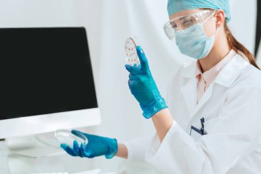 Kadın mikrobiyolog laboratuarda araştırma yapıyor. .