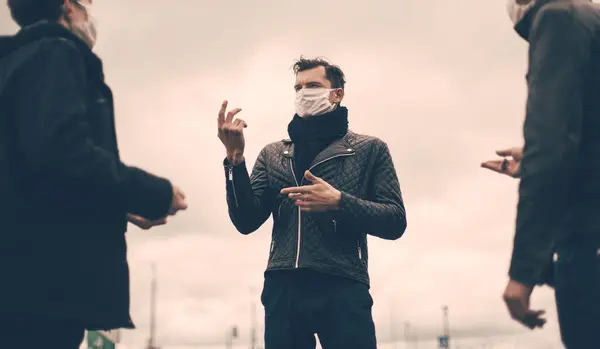 Jongeren met beschermende maskers praten op veilige afstand — Stockfoto
