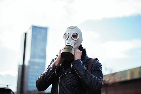 Ung man bär en gasmask på en stadsgata — Stockfoto