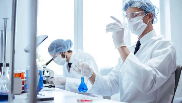 Os cientistas da imagem de fundo estão realizando pesquisas no laboratório. — Fotografia de Stock