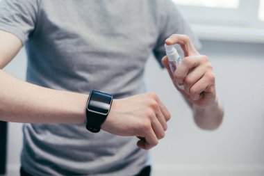 Kapat. Antibakteriyel sprey kullanan sıradan bir genç adam..