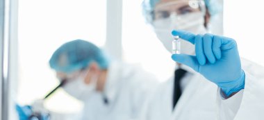 Bir bilim adamının arkaplan resmi test sonuçlarını bir laboratuvar günlüğünde kaydediyor.