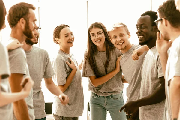 group of happy young people standing in a bright room