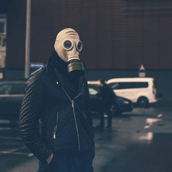 Pria bertopeng gas berdiri di tempat parkir kota — Stok Foto