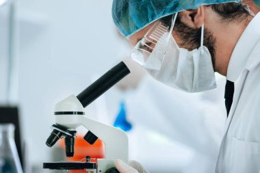 Laboratuvar asistanı laboratuarda testleri analiz ediyor..