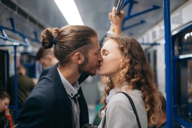 Bir adam ve bir kadın metroda öpüşürler..