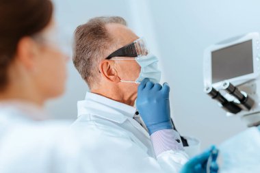 Kapat. Doktor laboratuvarda koruyucu bir maske takıyor..