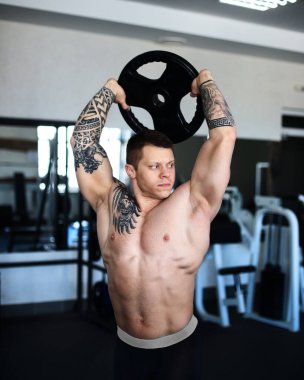 Odaklanan vücut geliştirici spor salonunda egzersiz yapıyor..