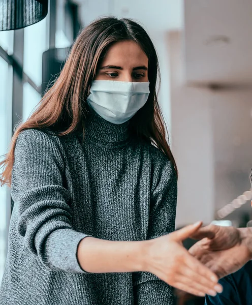 Personal joven con máscaras protectoras estrechando las manos entre sí. —  Fotos de Stock