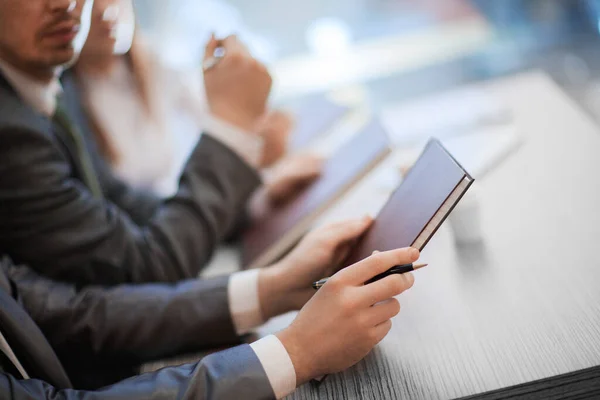 Bilden av en affärskollega som sitter vid ett bord vid ett arbetsmöte. närbild. — Stockfoto