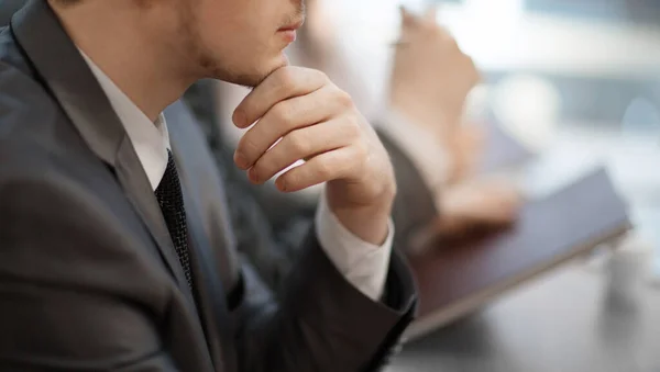 Omtänksam ung affärsman sitter vid sitt skrivbord. närbild. — Stockfoto