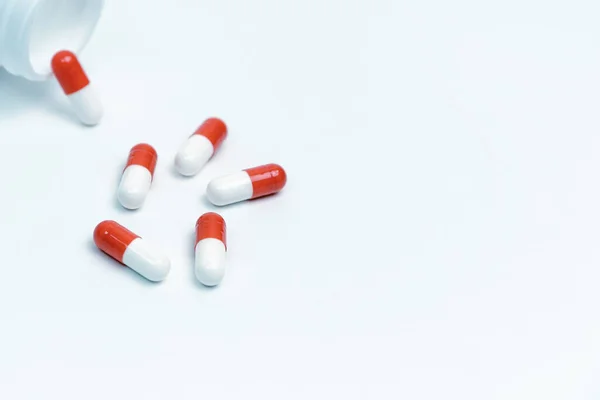 Cápsulas com medicamento e um frasco sobre fundo branco. — Fotografia de Stock