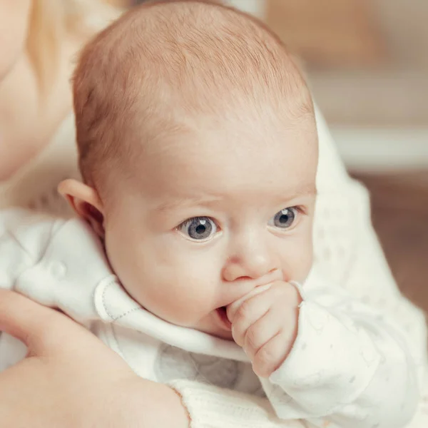 Moeder met baby zit bij de open haard in een gezellige woonkamer — Stockfoto