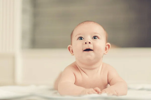 Jolie bébé couché et levant les yeux dans la surprise — Photo