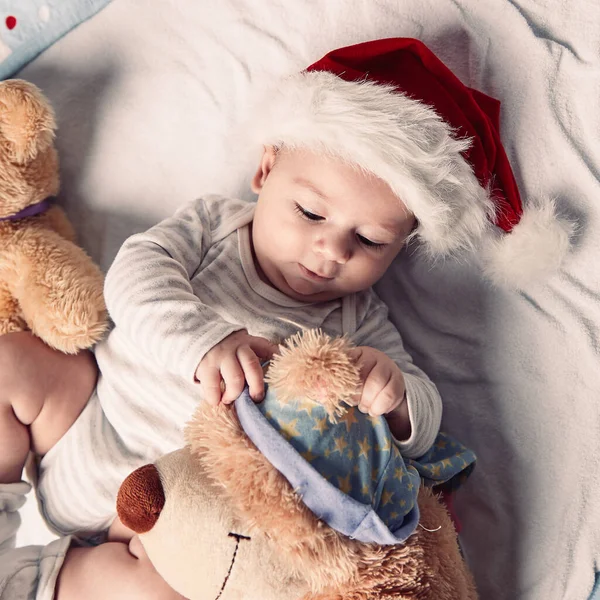 Mutlu bebek Noel Baba şapkası içinde yumuşak oyuncaklarla — Stok fotoğraf