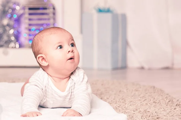 Mooie baby in een gezellige woonkamer op kerstavond — Stockfoto