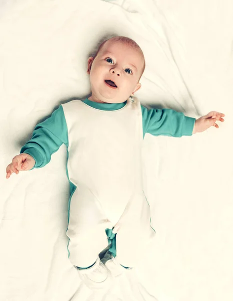 เด็กน่ารักในชุดเพนกวินนอนบนผ้าห่ม . — ภาพถ่ายสต็อก
