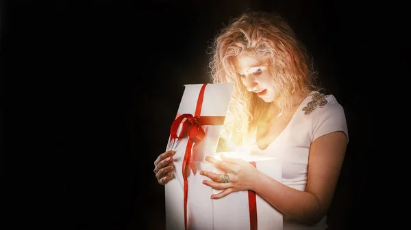 Mooie jonge vrouw openen geschenkdoos. geïsoleerd op zwart — Stockfoto