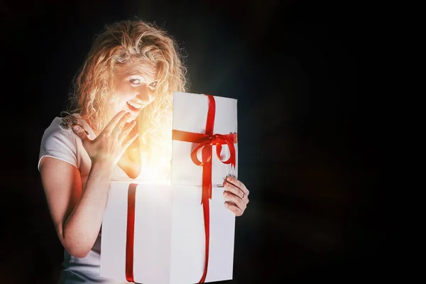 Gelukkige jonge vrouw openen geschenkdoos. geïsoleerd op zwart — Stockfoto