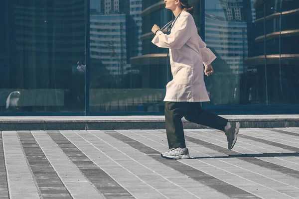 Γυναίκα γιατρός τρέχει κάτω από ένα δρόμο της πόλης. — Φωτογραφία Αρχείου