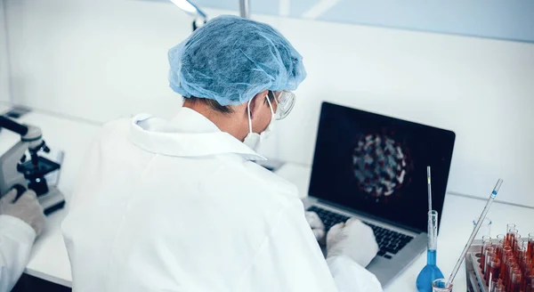 Visão traseira. cientista sentado em uma mesa no laboratório. — Fotografia de Stock