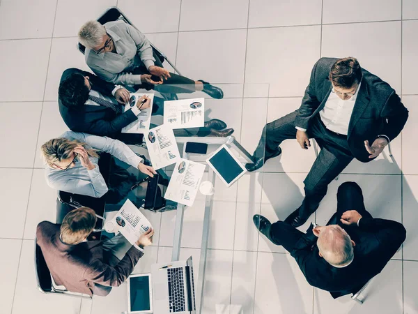 Vista dall'alto. gruppo di uomini d'affari che discutono nuove offerte finanziarie. — Foto Stock