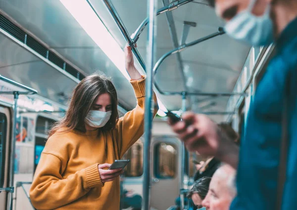 Pessoas com smartphones em pé em um carro de metrô. — Fotografia de Stock