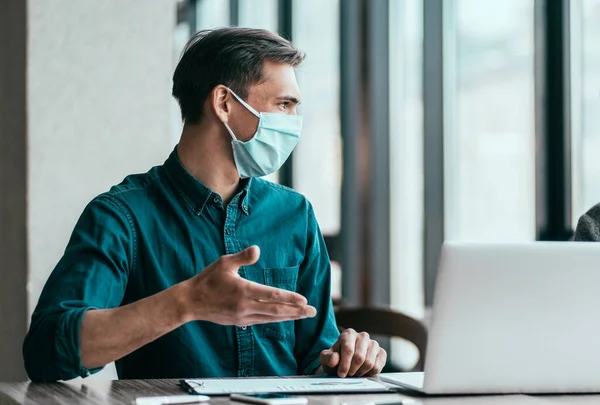 employees in protective masks discussing work issues.