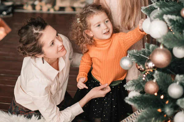 Mom and her little daughters decorating the Christmas tree — Stock Photo, Image
