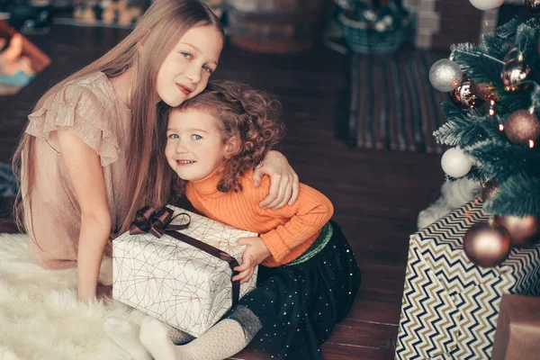 Two pretty sisters sitting on the floor on Christmas eve — Stock Photo, Image