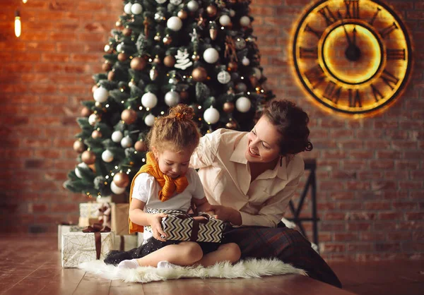 Máma mluví se svou dcerou, sedí u vánočního stromečku — Stock fotografie