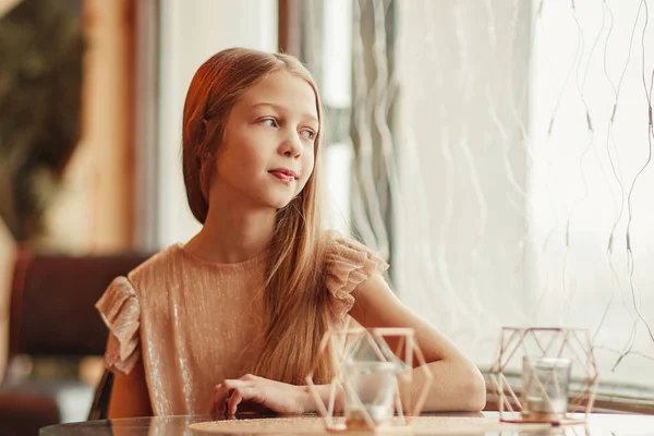 Linda chica sentada en una mesa en un café — Foto de Stock