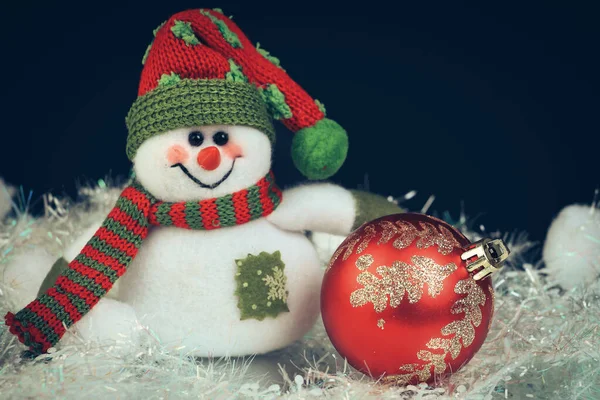 Leksak snögubbe med festlig röd boll på en svart bakgrund — Stockfoto