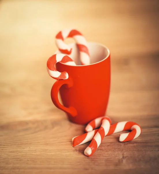 Caneca de Natal e vela no fundo de madeira — Fotografia de Stock