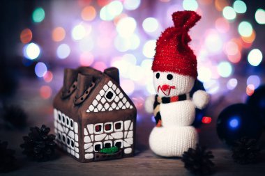 Oyuncak kardan adam ve zencefilli kurabiye evi Noel masasında
