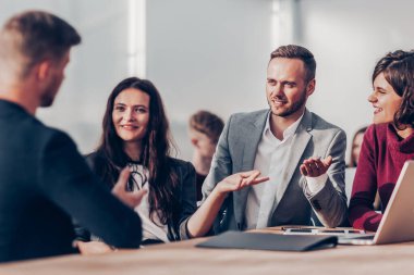 Bir ofis toplantısında iş konularını tartışan çalışanlar