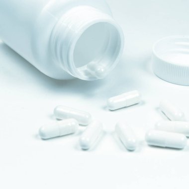 Beyaz arka planda şişe ve haplar..