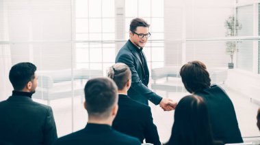 İş arkadaşları el sıkışarak birbirlerini selamlıyorlar.