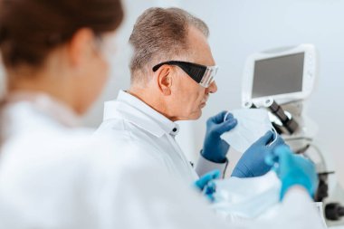 Bilim adamları bir tıp laboratuarında koruyucu bir maske takıyorlar. .