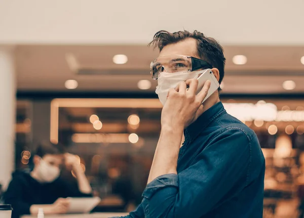 Homme en masque de protection parlant sur son smartphone — Photo