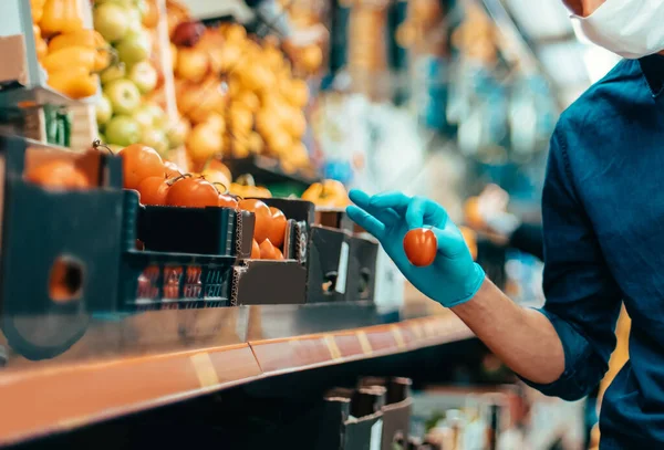 Acheteurs en masques protecteurs choisissant des fruits au supermarché — Photo