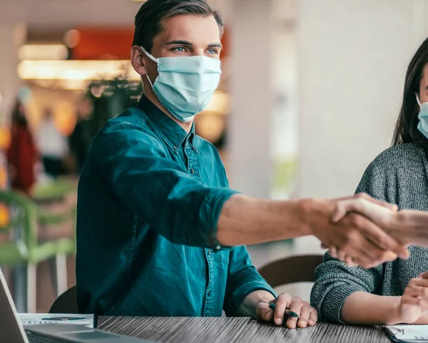 Zakenmensen schudden handen over een bureau. — Stockfoto