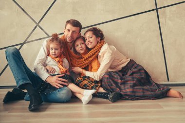 Mutlu ebeveynler ve kızları yeni bir dairede yerde oturuyorlar.