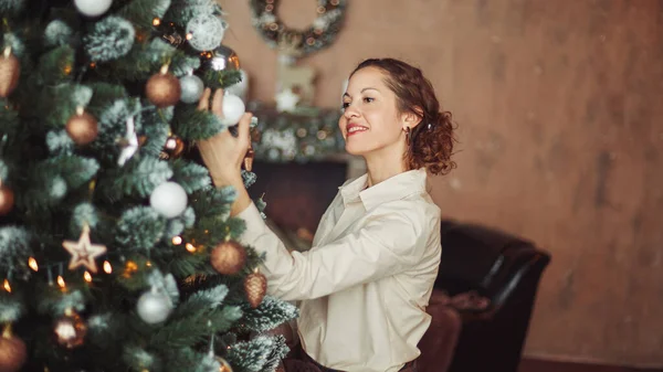 Bela jovem mulher decoração árvore de Natal em sua sala de estar — Fotografia de Stock