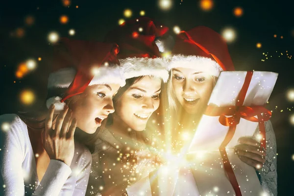 Meninas com um presente de ano novo em um fundo escuro — Fotografia de Stock