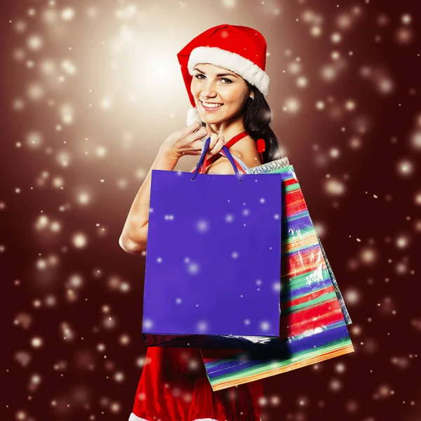 Feliz jovem mulher vestida como Papai Noel com as compras de Natal. — Fotografia de Stock