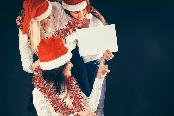 Tři mladé dívky v kostýmu Santa Clause ukazující prázdné listy — Stock fotografie