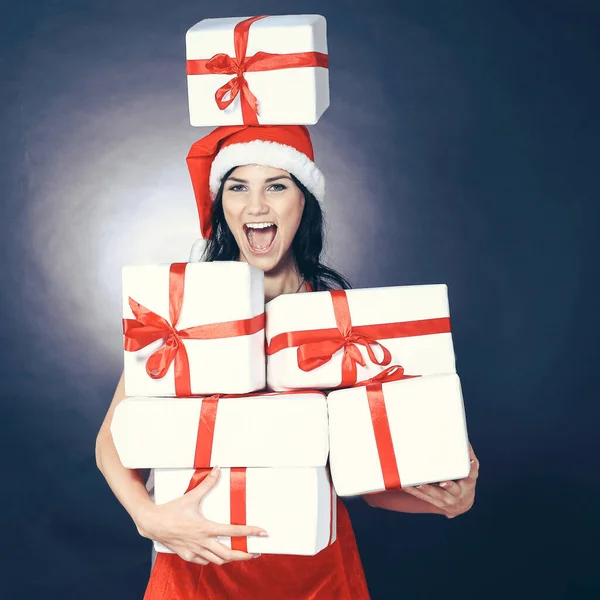 Gelukkige jonge vrouw in kostuum van de kerstman met veel kerstinkopen. — Stockfoto